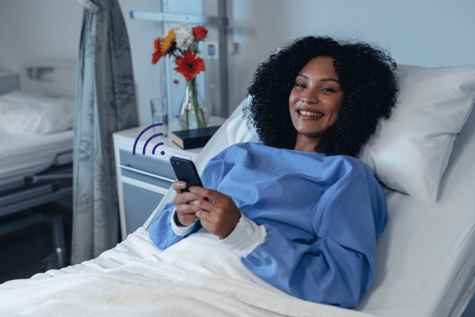 Patient utilisant son téléphone dans un lit d'hopital